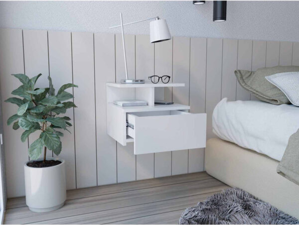 Aprovecha la oferta de La mesa de noche flotante en color blanco es el mueble perfecto para quienes buscan optimizar el espacio en su dormitorio sin comprometer el estilo. Su diseño moderno y minimalista, junto con su cajón sin tirador y sus dos divisiones inferiores, proporciona una solución funcional y estética para organizar y decorar tu habitación.