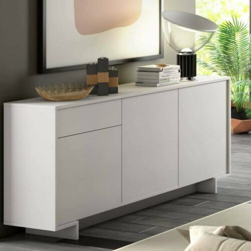 Diseño Moderno y Versátil: Este aparador, con un diseño minimalista, será un aporte práctico y decorativo para tu hogar. Con 3 puertas, el aparador proporciona amplio espacio de almacenamiento para libros, dispositivos multimedia y otros artículos. La robusta superficie es ideal para exhibir objetos decorativos, marcos de fotos o plantas. También se puede usar como mueble bajo, armario auxiliar, etc. Gracias al tablero de gran calidad, este aparador está diseñado para durar.