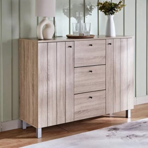 Aparador Color Roble con 3 Cajones, 2 Puertas: Moderno y Elegancia, Funcionalidad para Tu Hogar Renueva tu espacio con nuestro aparador en color roble, diseñada para ofrecer estilo y practicidad. Con 3 cajones, 2 puertas , este aparador es la solución perfecta para mantener tu hogar organizado. Equipado con apertura  de tiradores de aluminio en negro y fabricado con melamina de alta calidad de 18 mm, este mueble garantiza durabilidad y resistencia. Sus medidas de 90 cm de alto,  120 cm de largo y 40 cm de profundidad la hacen ideal para cualquier habitación de tu hogar. Beneficios y Cualidades 1. Diseño Elegante y Moderno: El aparador en color roble presenta un diseño contemporáneo que se adapta a cualquier estilo de decoración. El acabado en roble aporta calidez y sofisticación, mientras que la apariencia con tiradores negros añaden un toque de modernidad y elegancia. 2. Amplio Espacio de Almacenamiento: Con 3 cajones, 2 puerta, este aparador ofrece un generoso espacio de almacenamiento para organizar tu ropa, accesorios, documentos y otros objetos personales. Los cajones  permiten tener todo al alcance de la mano, manteniendo tu habitación ordenada y libre de desorden.