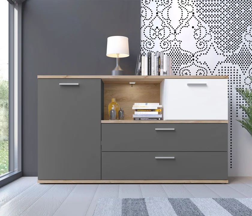 Cómoda de 2 Cajones, Estantes 2 PuertaS Con Divisiones Internas  - Calidad y Estilo para tu Hogar Descubre los Beneficios y Cualidades de Nuestra Cómoda de 2 Cajones con Correderas Telescópicas y 2 Puertas Abatible ¿Buscas una solución de almacenamiento elegante y funcional para tu hogar? Nuestra cómoda de 3 cajones 3 estantes con puerta abatible es la opción perfecta. Diseñada para combinar estilo y practicidad, esta pieza de mobiliario se convertirá en un imprescindible en cualquier habitación. A continuación, destacamos sus principales Invierte en el bienestar y la felicidad de tus hijos con esta cómoda . Este precioso mueble aporta un toque moderno a cualquier espacio. Con unas impresionantes dimensiones de 150 cm de ancho, 86 cm de alto y 40 cm de profundidad, ofrece un amplio espacio de almacenamiento para las pertenencias de tus hijos en crecimiento. La elegante cómoda es el complemento perfecto para cualquier habitación infantil. Esta cómoda resistente, con acabado en grafito y detalles en roble y blanco, cuenta con dos puertas de cierre suave y dos cajones de apertura total, ofreciendo un amplio espacio de almacenamiento. El compartimento abierto proporciona espacio adicional para exhibir objetos. La elegante combinación de colores grafito, blanco y marrón crea un punto focal llamativo y añade un toque moderno a cualquier habitación infantil. beneficios y cualidades: Amplios Cajones con Correderas Telescópicas Con dos espaciosos cajones equipados con correderas telescópicas de alta calidad, nuestra cómoda facilita un acceso suave y sin esfuerzo a tus pertenencias. Estos cajones ofrecen un almacenamiento amplio y organizado, ideal para guardar ropa, accesorios, documentos y más.